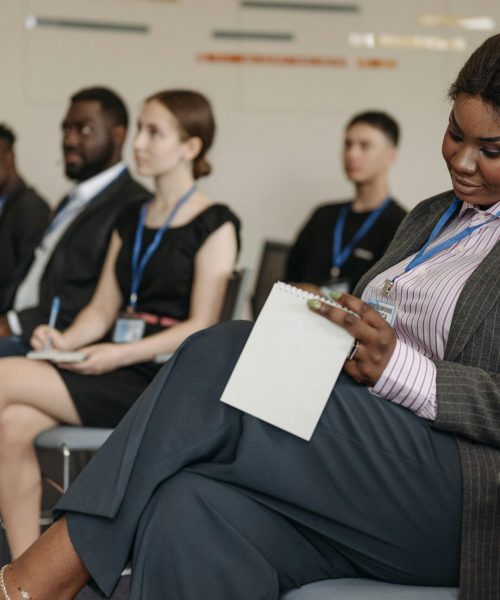 Business professionals engaged in a seminar, taking notes and listening attentively.